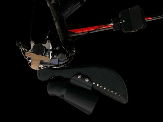Cyclodapt device assembled on a mountain bike handlebar, showing the cuff, scaffolding, and knee brake components.